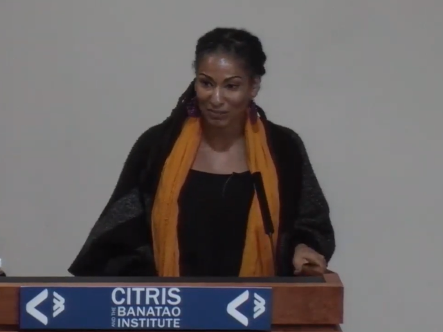 Ruha Benjamin speaking at a podium